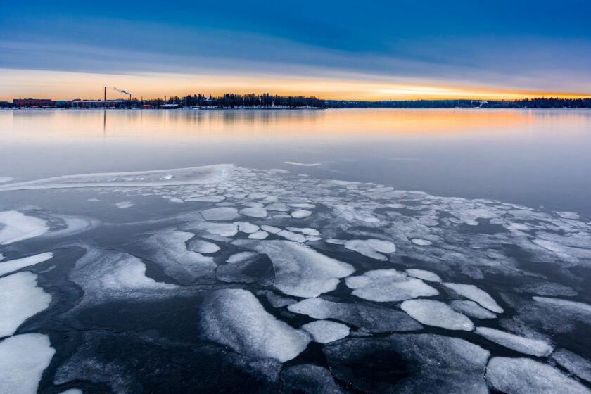 Jäätä ja sulaa järveä, taustalla auringonlasku